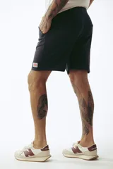 Shorts de algodón color rosa viejo, estilo jogging, con cordón ajustable en la cintura y corte por encima de la rodilla.