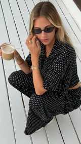 Pantalón negro de algodón y viscosa, con estampado de lunares blancos y corte holgado.