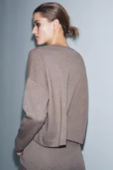 Top de tejido soft con cuello redondo, manga larga y bajo recto.