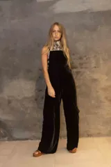 Enterito de terciopelo negro con diseño de pierna ancha y bolsillos laterales tipo cargo. Presenta espalda descubierta con tiras ajustables y bordado decorativo en la parte trasera.