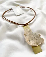 Collar con cordón doble de cuero marrón, dije rectangular de metal dorado y dije irregular de nácar con orificios.