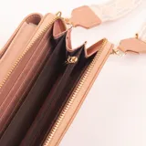 Porta celular color rosa con correa de tela estampada.