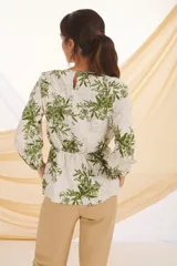 Blusa de manga larga con estampado floral en tonos verde y blanco.