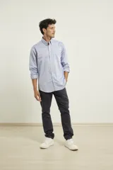 Camisa celeste de algodón con cuello abotonado, manga larga con puños abotonados y bolsillo en el pecho. Corte clásico.