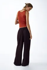 Pantalón de punto color marrón oscuro, de tiro alto con cintura elástica, cordón de ajuste y diseño de piernas amplias.