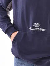 Buzo hoodie azul petróleo con bolsillo tipo canguro y estampado de un globo terráqueo y texto en blanco.