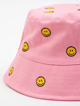Gorro tipo bucket color rosa con estampado de caritas sonrientes amarillas.