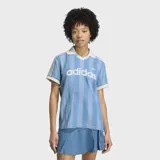 Remera de estilo deportivo inspirada en el fútbol, confeccionada en tejido denim de algodón con efecto lavado. Presenta un diseño de rayas verticales sutiles, cuello polo en color blanco, mangas cortas con bordes en contraste y el logo de la marca estampado en el frente.