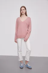Sweater de punto color rosado, con cuello en V, manga larga y diseño holgado.