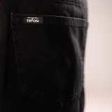 Bermuda de jean negro de corte holgado y largo hasta la rodilla, con diseño clásico de cinco bolsillos y cierre frontal.