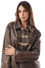 Campera estilo militar napoleón confeccionada en cuero ovino, con cierre frontal y solapa decorativa con botones metálicos y alamares de gamuza en tono crudo. Cuenta con cuello camisero, pespuntes visibles y diseño estructurado de manga larga.