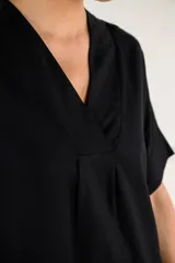 Túnica midi de color negro, con escote en V, mangas cortas y corte holgado. Confeccionada en una mezcla de viscosa y lino, ofrece una caída ligera y cómoda.