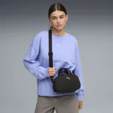 Mini bolso Puma modelo UP Grip, color negro con textura arrugada. Cuenta con doble asa de mano, correa ajustable extraíble, cierre superior y logo de la marca en dorado en el frente.