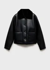 Chaqueta de doble faz con exterior de cuero sintético negro y forro interior de pelo sintético al tono. Presenta cuello camisero, cierre frontal con botones, manga larga y dos bolsillos de parche delanteros.
