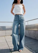 Pantalón de jean tiro medio con diseño de corte recto y cinco bolsillos. Presenta cierre de botón y cremallera, además de trabillas en la cintura.