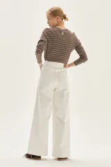 Remera de manga larga a rayas horizontales marrones y blancas, con cuello redondo y corte holgado.