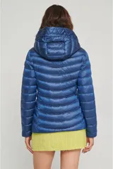 Campera puffer color beige claro, con capucha y cierre frontal.