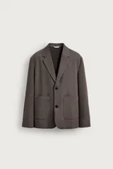 Blazer de corte relaxed fit color marrón oscuro, con cuello de solapas de muesca, cierre frontal de dos botones y bolsillos de plastrón en la cadera.