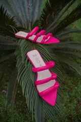 Sandalias negras de cuero con punta fina y tiras finas con nudos.