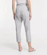 Pantalón baggy de sarga con diseño de rayas verticales, cintura alta elástica con lazo ajustable, bolsillos laterales y corte recto ligeramente cropped.