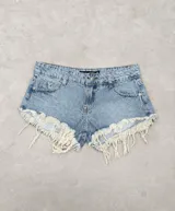 Short de denim celeste con efecto deslavado, tiro medio, bolsillos clásicos y flecos largos de hilo crudo en las piernas.