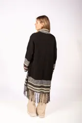 Levita abierta de punto en color negro, con diseño de guardas étnicas en los bordes frontales, puños y ruedo. Presenta terminaciones con flecos en la parte inferior y mangas largas.