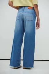 Pantalón de jean azul de tiro medio/bajo, con calce extra relaxed y piernas anchas. Confeccionado en denim rígido liviano, con lavado acid wash azul y desflecado en ruedos.