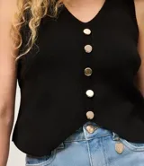 Chaleco sin mangas de tejido de punto negro, con escote en V y cierre frontal mediante una hilera de botones metálicos dorados.