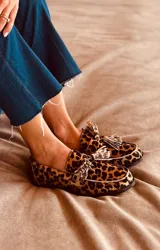 Alpargata mocasín de gamuza color marrón con estampado animal print de leopardo y detalle de borlas en el empeine.