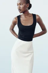 Camiseta blanca ajustada de poliamida con tirantes anchos y escote redondo.