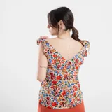 Blusa negra con estampado de flores celestes y hojas verdes, con breteles finos con volados.