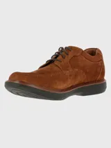 Zapato de estilo casual confeccionado en cuero gamuzado color marrón, con cierre de cordones y suela de goma EVA negra. Presenta costuras reforzadas en la puntera y detalle de logo grabado en el lateral.