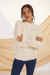 Sweater de punto calado color lila con cuello alto.