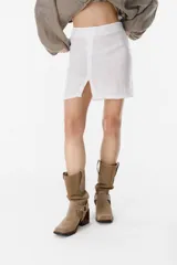 Minifalda blanca de lino con abertura frontal.