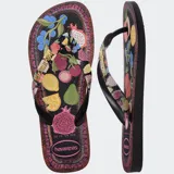 Ojotas Havaianas Top Tropicalia Vibes II con base negra y estampado de frutas tropicales en colores vibrantes. Las tiras son negras con el logo de Havaianas en dorado.