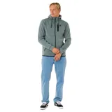 Campera técnica con cierre frontal completo, capucha ajustable con cordones y bolsillos laterales con cierre. Presenta un bolsillo adicional en el pecho con cierre termosellado y logo de la marca. Diseño de tejido técnico en color verde jaspeado.