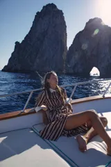 Vestido midi camisero de rayas verticales en tonos bordó y blanco, con cuello solapa y puños en color contrastante. Cuenta con mangas largas, cierre frontal de botones y un cinturón ajustable con hebilla metálica en la cintura.