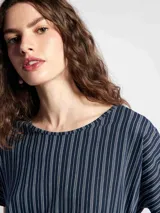 Blusa de manga corta con cuello redondo y estampado de cuadrícula blanca sobre fondo color tostado.