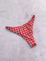 Bombacha de bikini vedetina con estampado de pata de gallo en tonos rojo y gris.