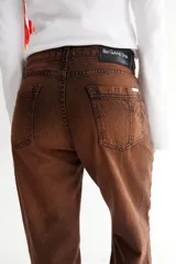 Jean negro de corte recto con recortes laterales, roturas en bolsillos, pespuntes a contratono y zigzag característico de la marca BG.