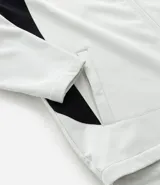 Campera deportiva con capucha, color blanco con recortes laterales en negro. Cuenta con cierre frontal, bolsillos funcionales y ajuste en la cintura.