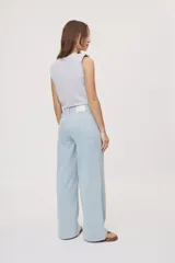 Pantalón wide leg de tiro medio con estampado de rayas verticales, diseño de cinco bolsillos, presillas para cinto y cierre frontal con botón y cremallera.