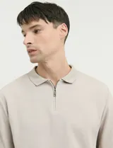 Remera de punto canalé francés con cuello polo, manga larga y cierre frontal de metal con tirador personalizado.