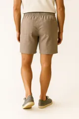 Short de lino color verde militar, con cintura elástica y cordón ajustable. Cuenta con bolsillos laterales y un corte ancho.