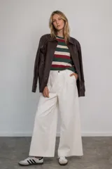 Pantalón tipo jean de corte wide leg y tiro alto, color blanco, con cierre frontal de botón y cremallera, y bolsillos laterales.