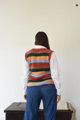 Chaleco de punto artesanal tejido a mano en lana 100% merino, con diseño de rayas horizontales en tonos terracota, verde, mostaza y azul.