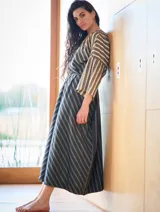 Vestido túnica gris con rayas verticales en tonos beige y negro, con lazo ajustable en la cintura.