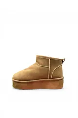 Pantubota corta de gamuza color negro, con plataforma gruesa y suela dentada. Cuenta con presilla en el talón para facilitar el calce.