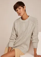 Sweater tejido en punto color gris claro, con cuello redondo y manga larga. Presenta diseño de trenzas en el frente y terminaciones acanaladas.