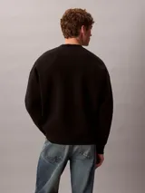 Buzo Calvin Klein de cuello redondo, color negro, con manga larga, puños y dobladillo acanalados, y el logo de la marca bordado en el pecho en tono azul.